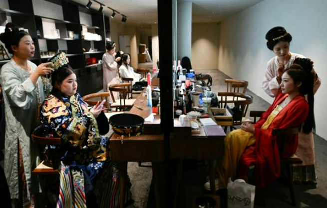 người phụ nữ mặc trang phục truyền thống của Trung Quốc chuẩn bị bữa ăn tại nhà hàng sân khấu ở Bắc Kinh