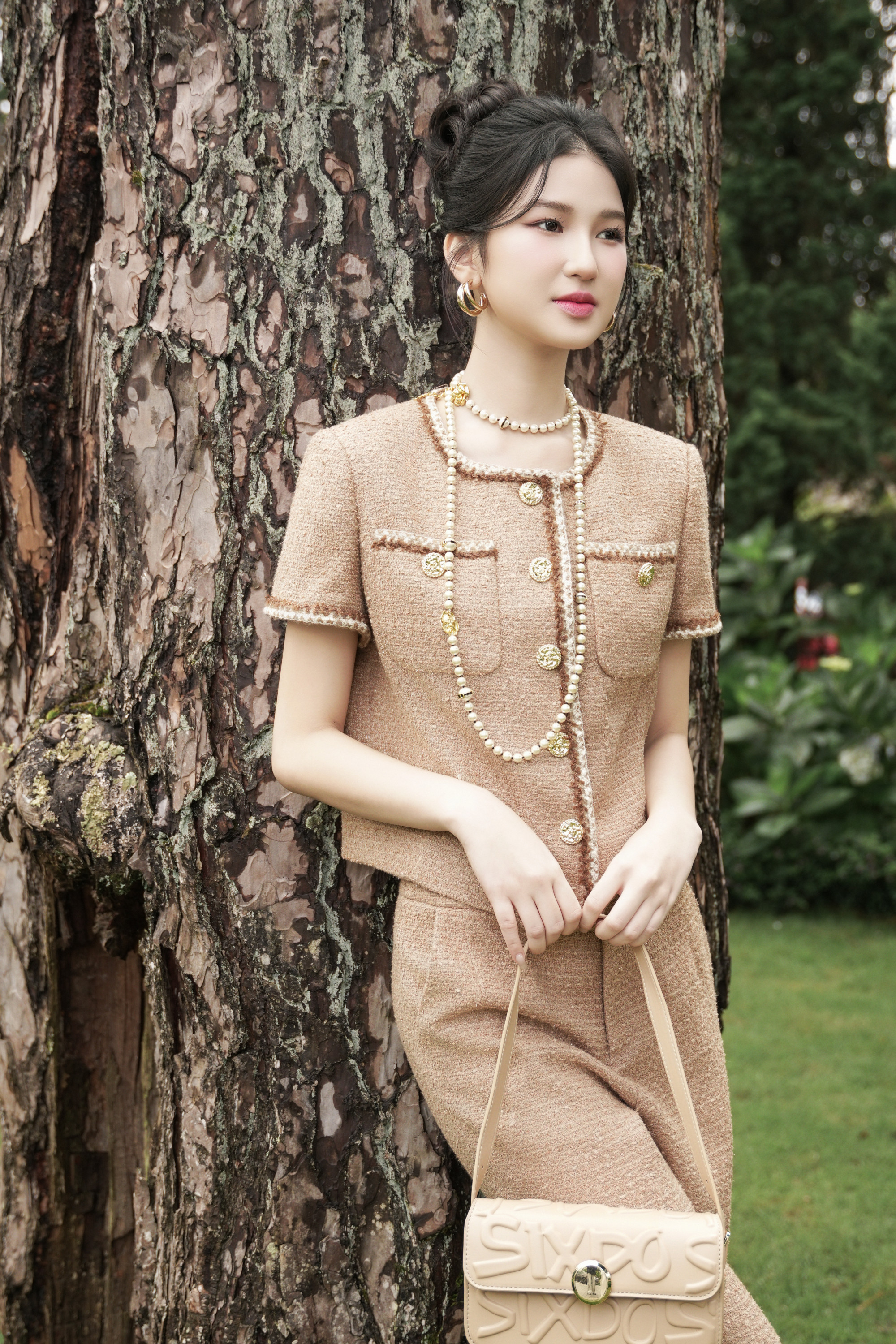 tweed được xử lý mềm và nhẹ hơn, mang đến cảm giác thoải mái, phù hợp với phong cách sống linh hoạt của phụ nữ hiện đại. Chất liệu uyển chuyển, chuyển động theo từng bước chân của người mẫu giữa khu vườn xanh mướt hay dọc hành lang cổ kính của resort mà không đánh mất phom dáng chuẩn mực .