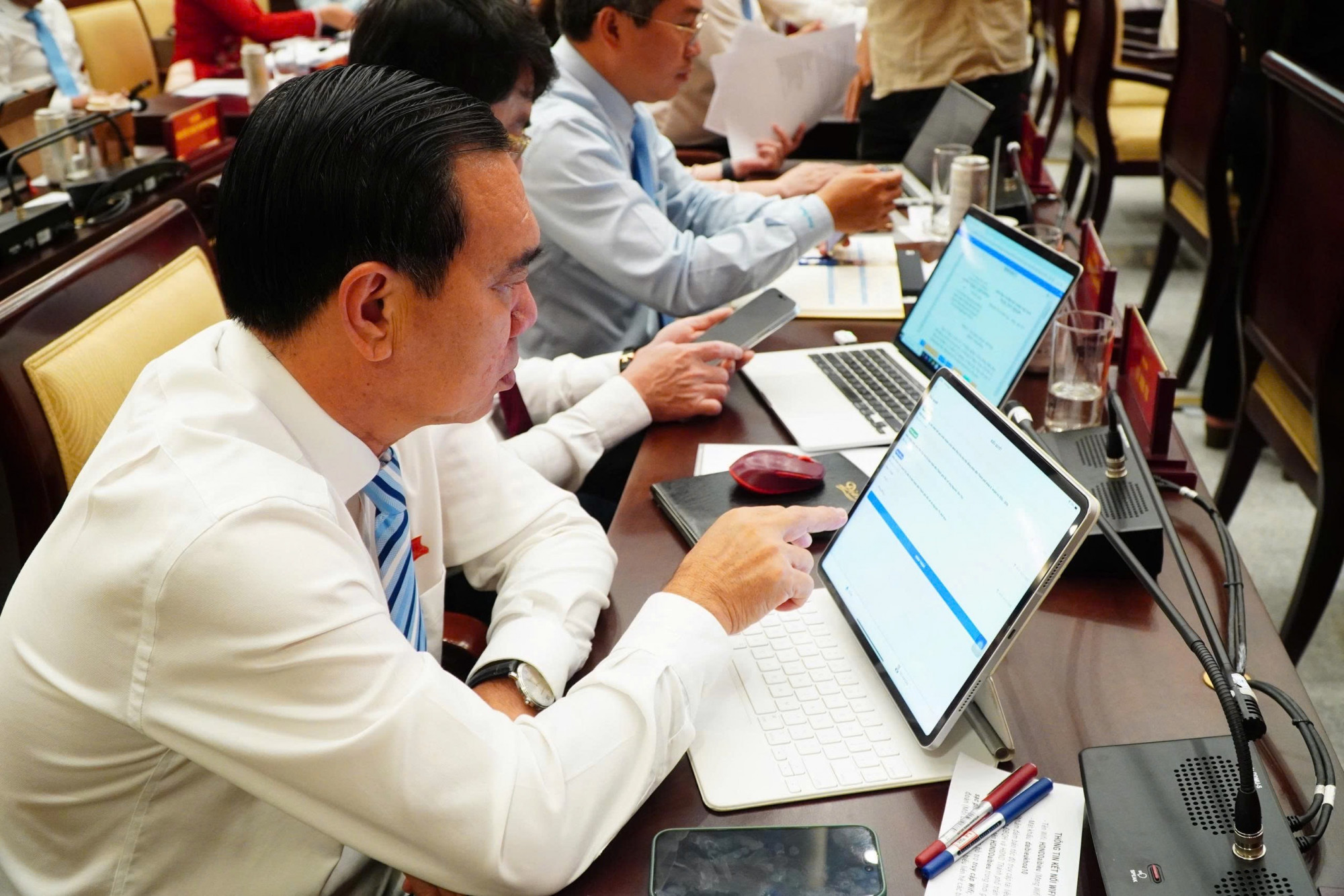 Các đại biểu HĐND đọc các tờ trình tại kỳ họp thứ 5, HĐND TPHCM - Ảnh: Thanh Tâm