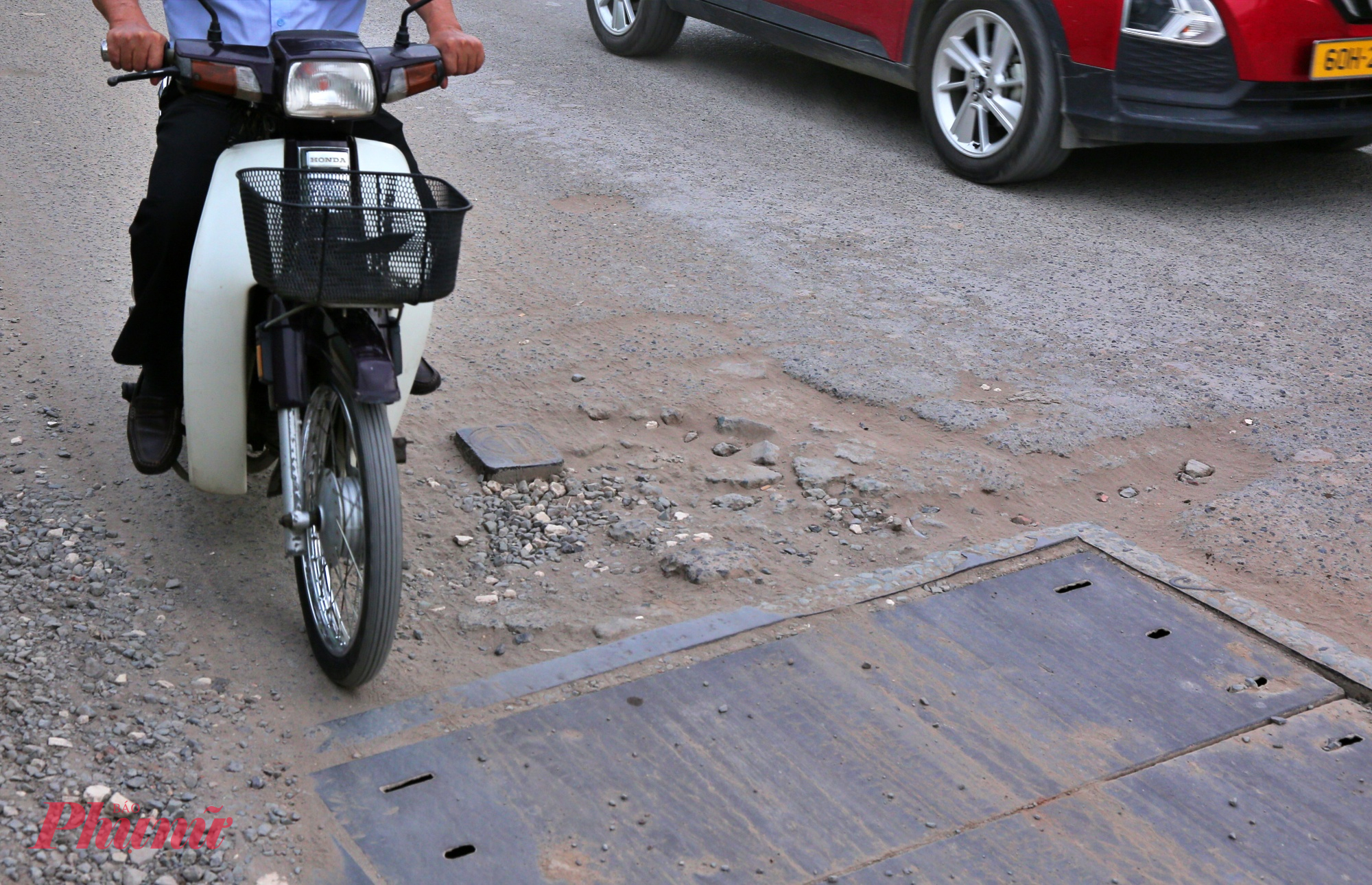 Đường cửa ngõ TPHCM xuống cấp, bụi dày phủ trắng nhà dân như sương mù Một số đoạn qua các nắp hố ga bị hư hỏng, xuống cấp