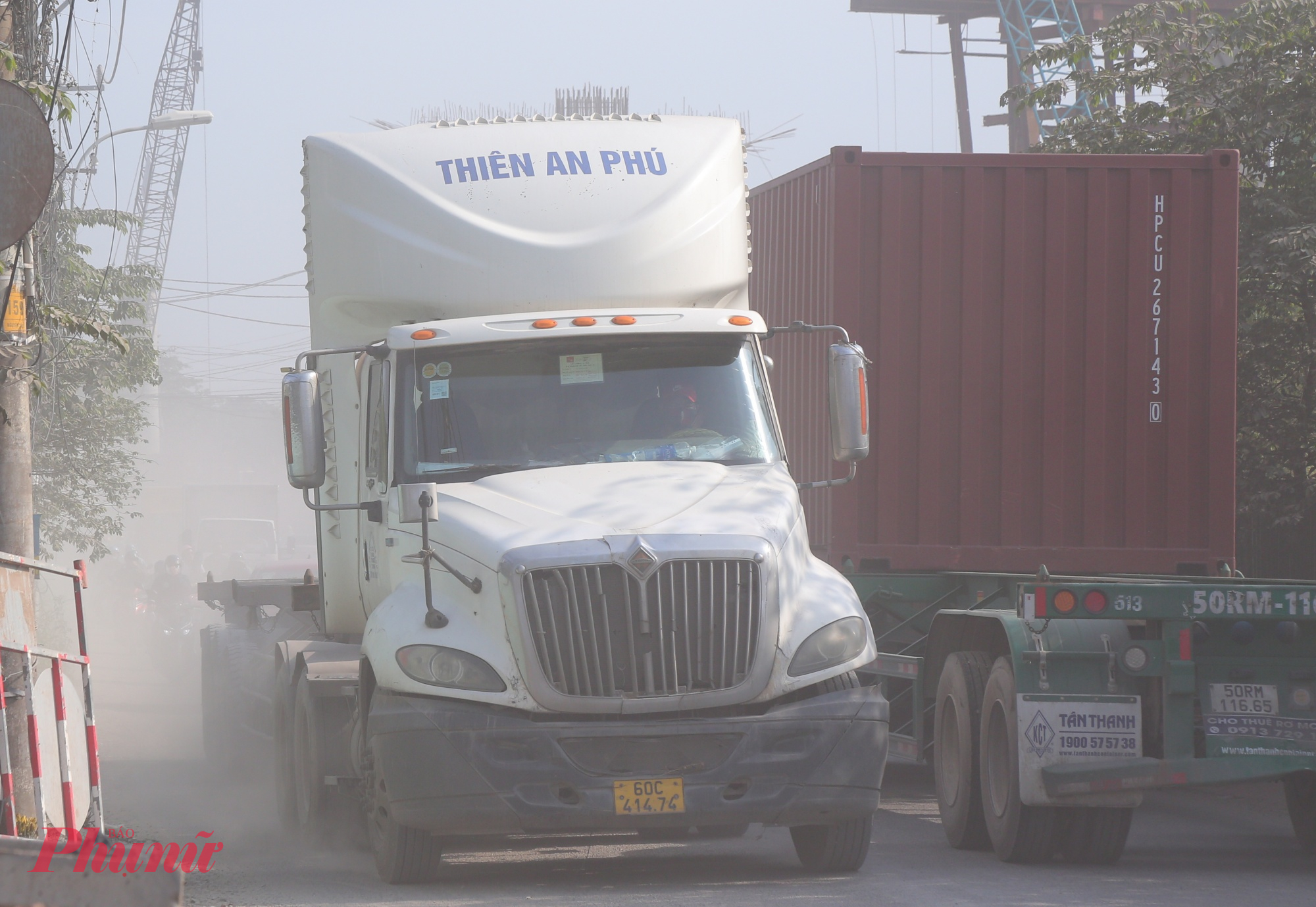 Đường cửa ngõ TPHCM xuống cấp, bụi dày phủ trắng nhà dân như sương mù Tài xế xe container ngồi trong cabin cũng phải đeo khẩu trang khi đi qua đường Nguyễn Xiển vì quá bụi