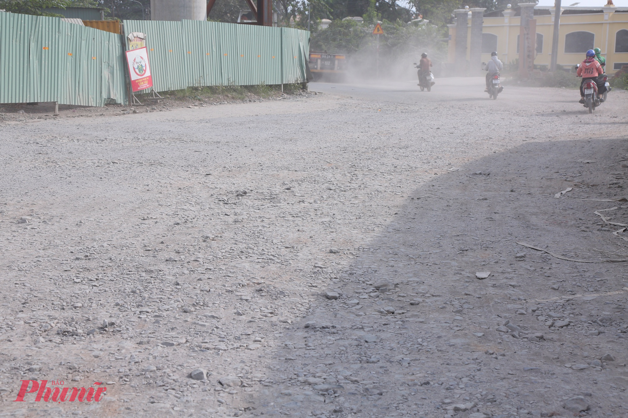 Đường cửa ngõ TPHCM xuống cấp, bụi dày phủ trắng nhà dân như sương mù Đường gập ghềnh đầy sỏi đá khiến xe máy dễ bị trượt.