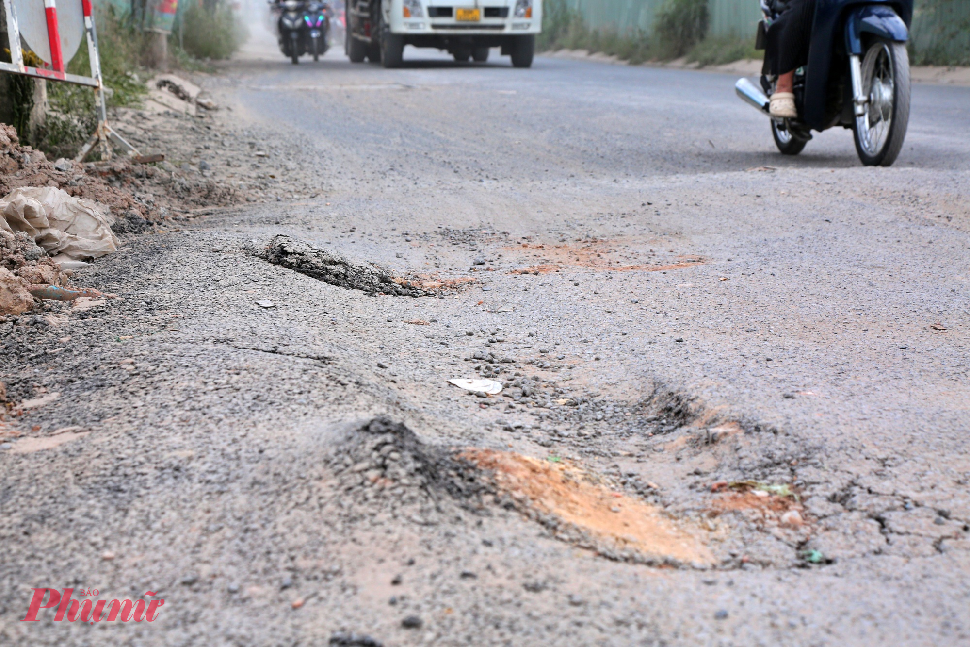 Đường cửa ngõ TPHCM xuống cấp, bụi dày phủ trắng nhà dân như sương mù Mặt đường có đoạn bị lún do xe ben, xe container chạy liên tục