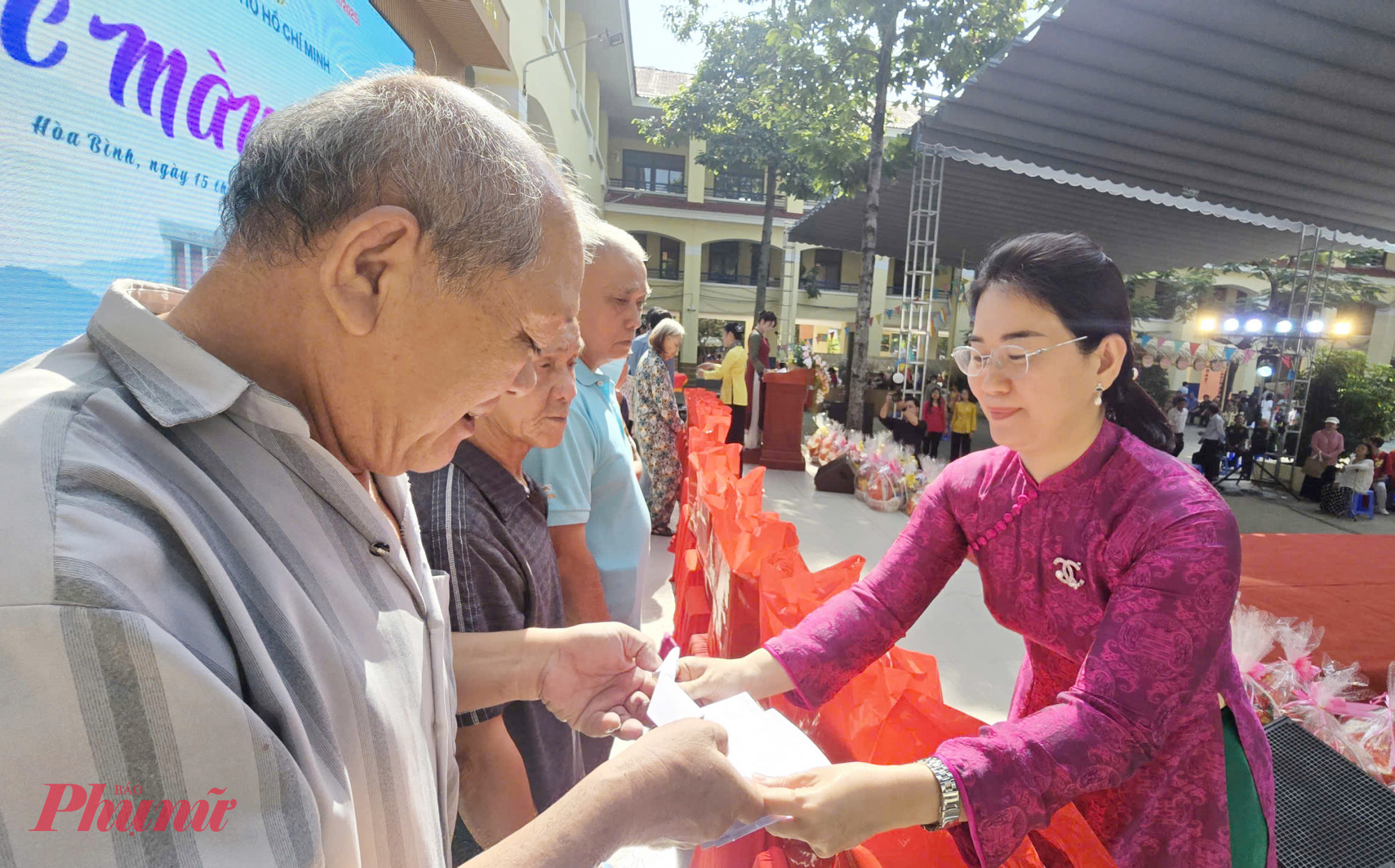 Bà Trần Thị Bích Trâm - Phó Bí thư Thường trực Đảng ủy phường Hòa Bình - tặng quà cho người dân -Ảnh: Trang Nguyễn 