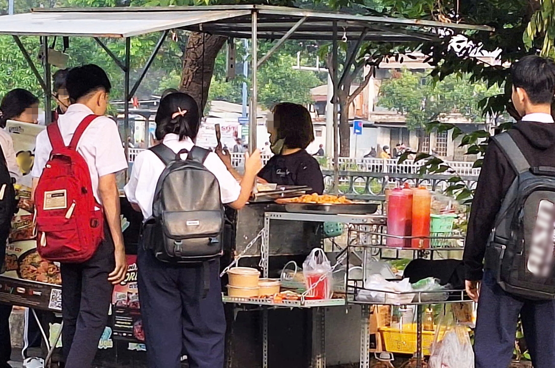 Bảo vệ sức khỏe học sinh bằng “vùng an toàn dinh dưỡng học đường” Đồ chiên, tương ớt không nhãn mác tại một xe bán mì trộn trước cổng trường - ẢNH: T.T.