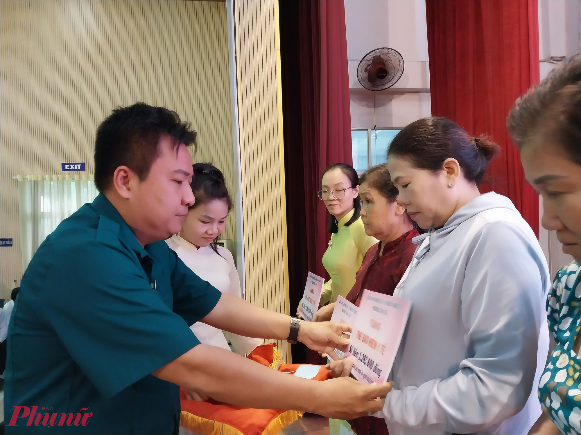 Ban tổ chức trao bảng tượng trưng tặng thẻ bảo hiểm y tế đến hội viên phụ nữ có hoàn cảnh khó khăn - Ảnh: Mẫn Nhi