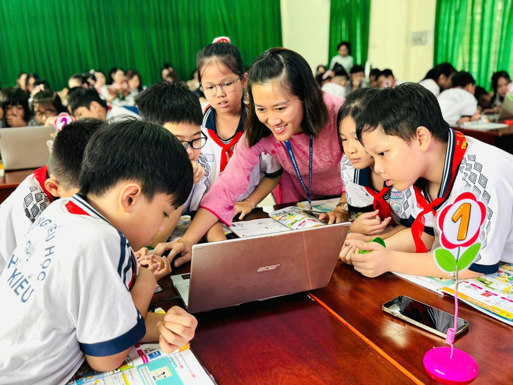Giáo viên Trường tiểu học Thuận Kiều, phường Đông Hưng Thuận, TPHCM  hướng dẫn học sinh lớp Bốn sử dụng thiết bị công nghệ để học tiếng Anh - ẢNH: TRANG THƯ