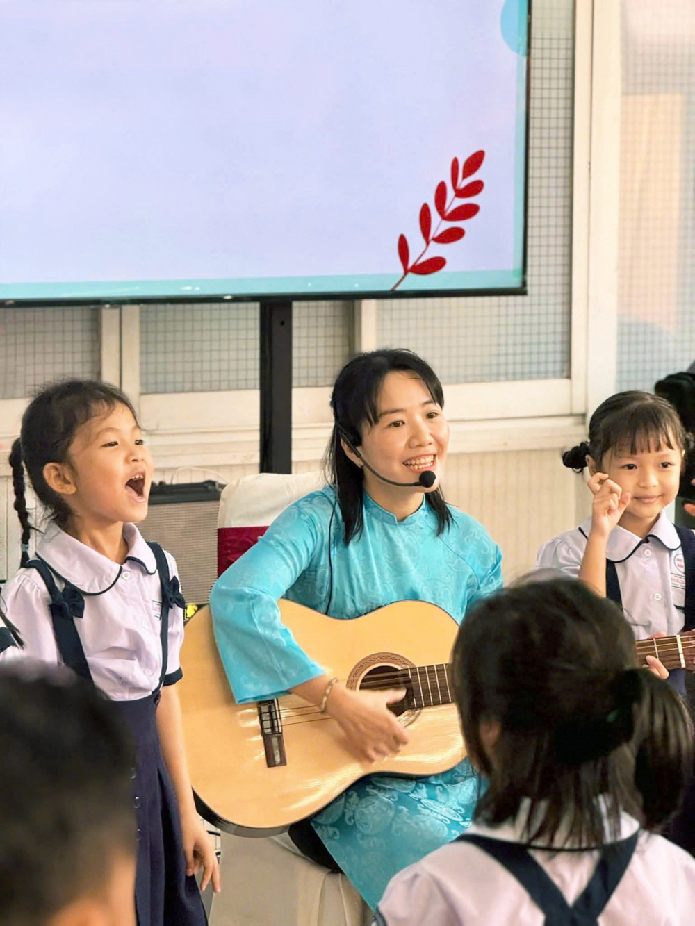 Giáo viên Trường tiểu học Đặng Trần Côn, phường Vĩnh Hội, TPHCM đàn hát cùng học sinh trong tiết học tiếng Anh ẢNH: TRANG THƯ