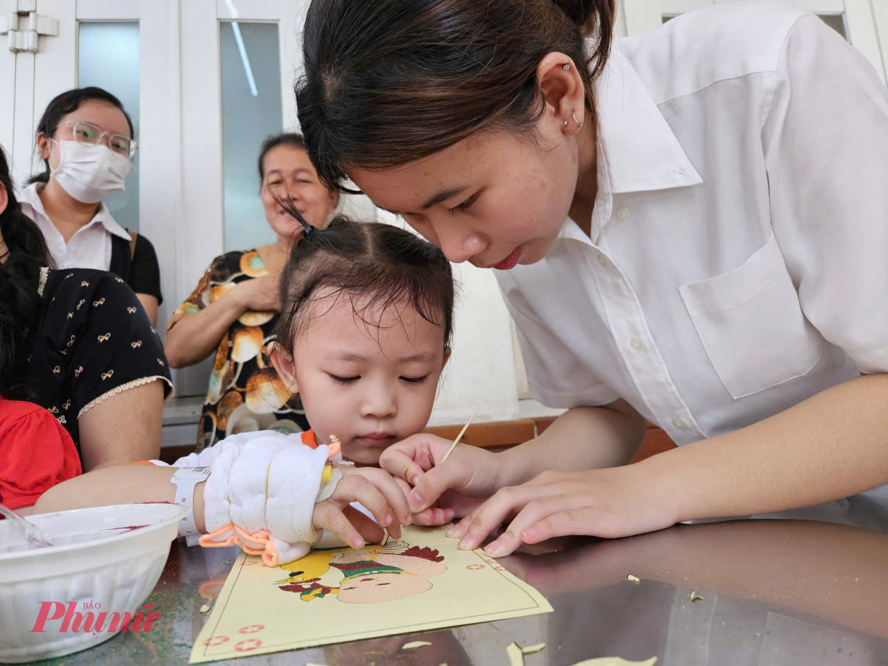Những bé nhỏ hơn cũng tham gia tô tranh, bé gái được anh, chị tình nguyện viên hướng dẫn tô tranh em bé ôm gà, bà ngoại của bé chia sẻ: Mấy ngày nằm viện căng thẳng, mệt mỏi lắm, nhờ có hoạt động này bà cháu tôi thoải mái tinh thần hơn, thấy bệnh viện lo cho các cháu như vậy tôi cũng rất yên tâm