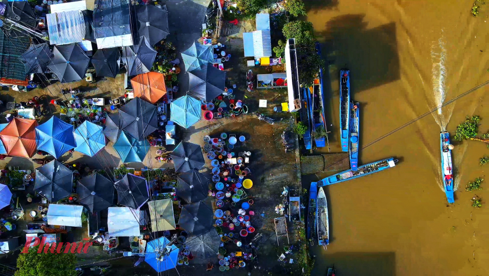 Miền Tây mùa nước nổi: hương vị phù sa nồng nàn và nồi lẩu mắm đậm đà ký ức Chợ quê miền Tây mùa lũ nhìn từ trên cao, rực rỡ với mái dù và xuồng ghe tấp nập.