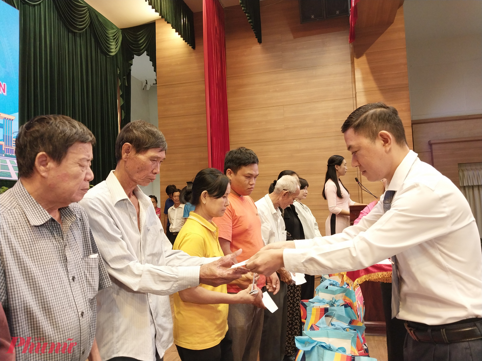 Đại diện các hộ dân nhận quà từ ban tổ chức - Ảnh: Mẫn Nhi