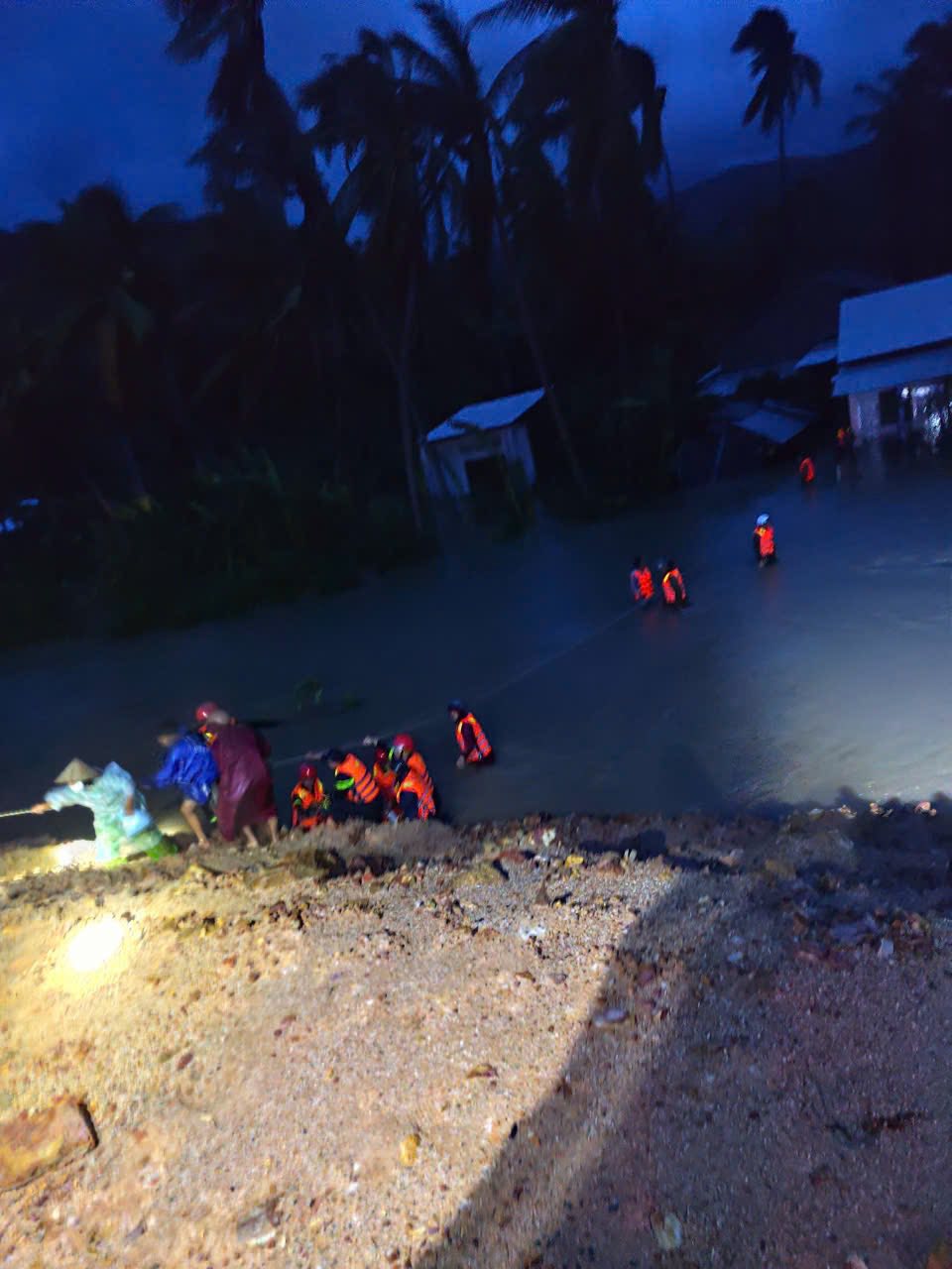 Do đoạn quốc lộ 1A này ngập sâu, người và phương tiện không thể qua lại, lực lượng công an tạo 'cây cầu người' đưa dân đến vùng an toàn