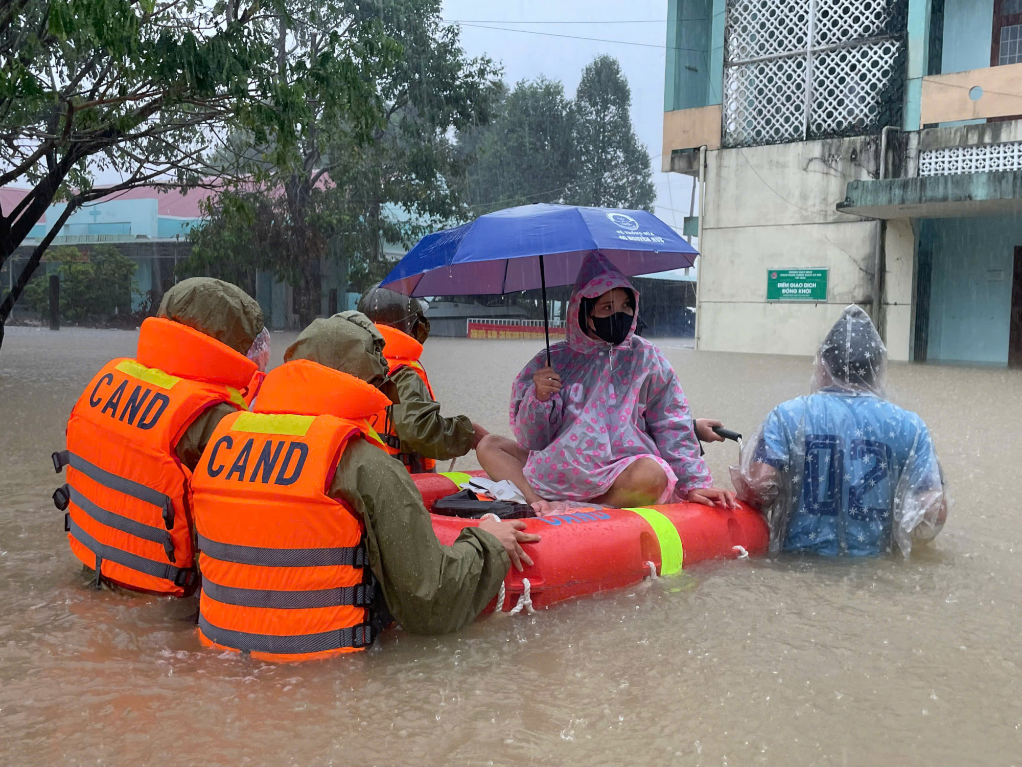 Lực lượng công an vượt lũ đưa sản phụ đến trạm y tế - Ảnh: CACC