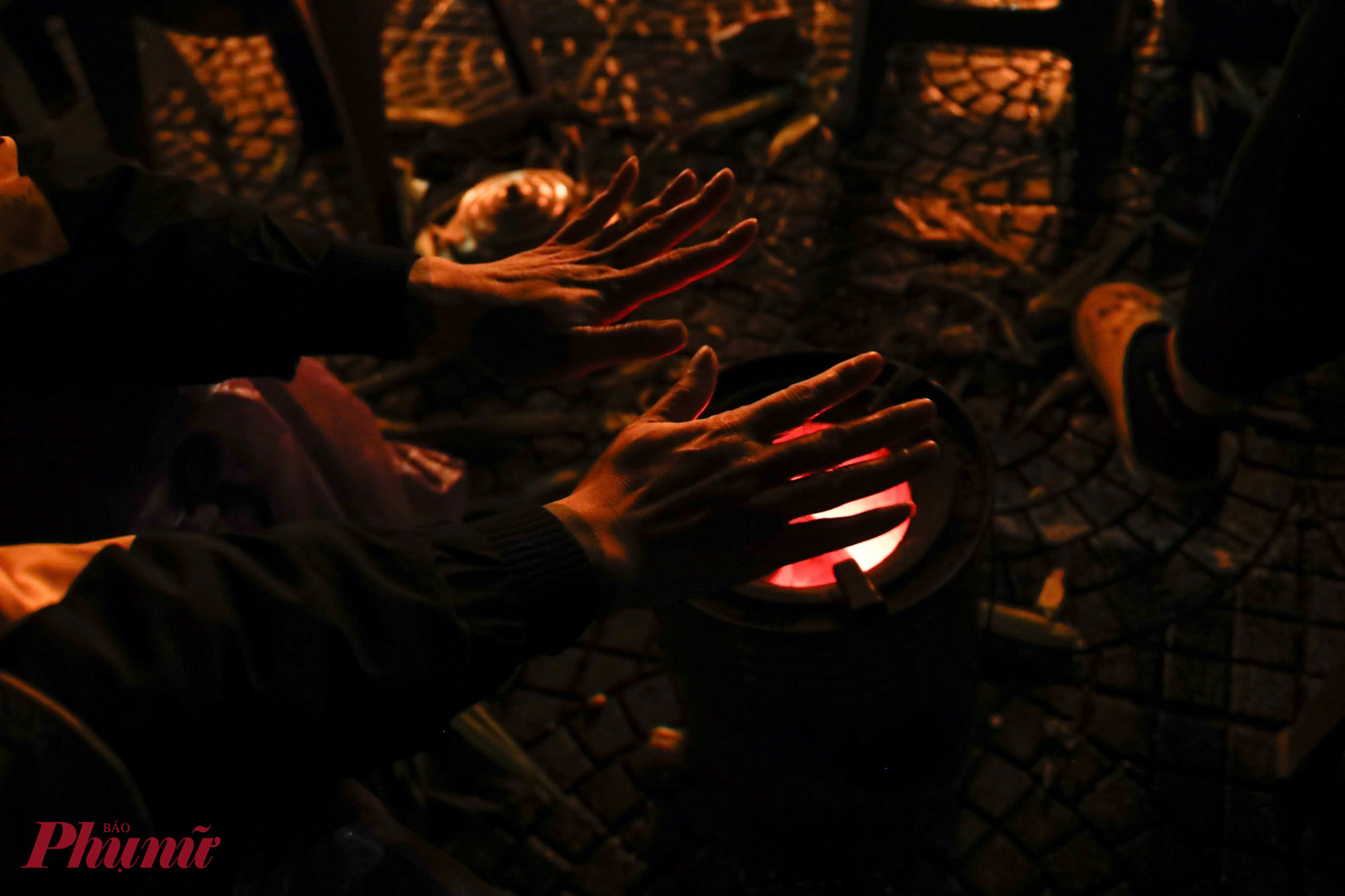 Khi nhiệt độ ngoài trời xuống thấp, một số người phải tìm cách sưởi ấm tạm thời ngay trên hè phố. 