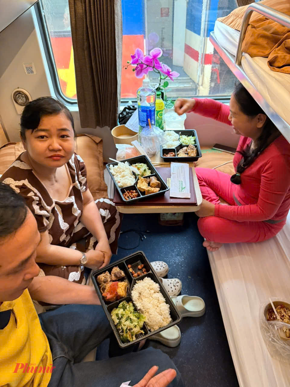 Hành khách được hỗ trợ thức ăn trong thời gian tàu dừng cho do mưa lũ gây ngập đường ray - Ảnh: ĐS