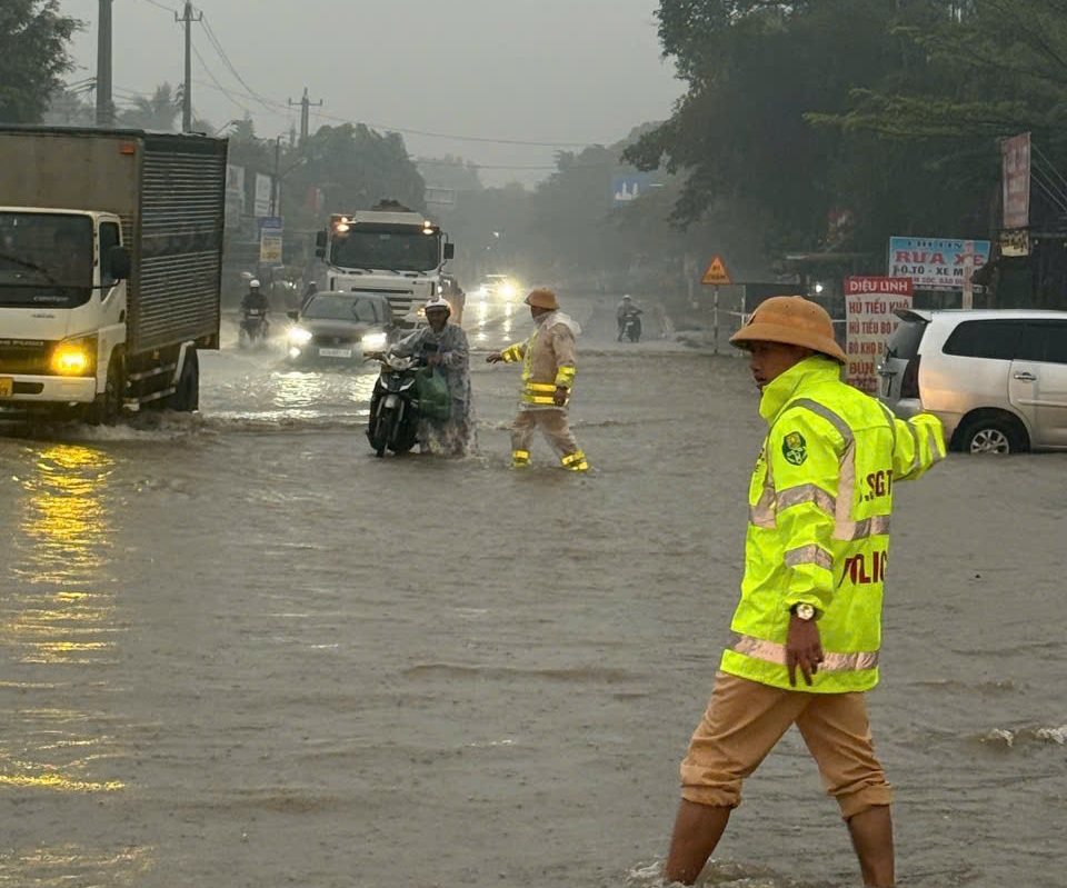 Lực lượng CSGT đội mưa để điều tiết giao thông, hỗ trợ người đi đường - Ảnh: CACC