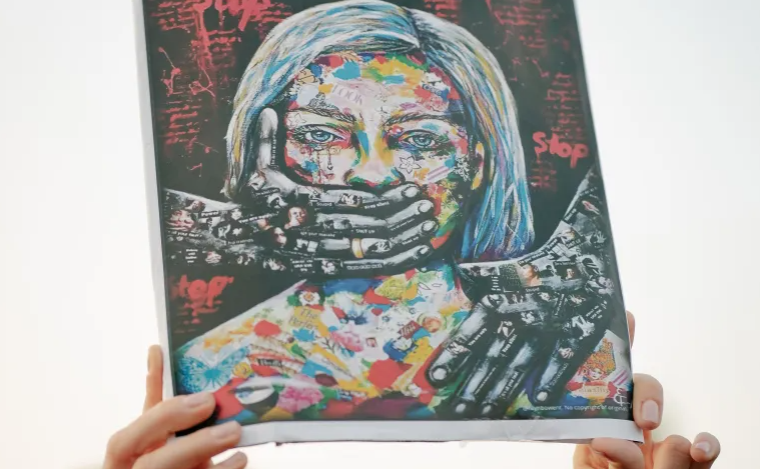 Một người biểu tình cầm một tấm biển trong một cuộc biểu tình vì quyền phụ nữ ở Bucharest, Romania, sau khi một phụ nữ bị giết bởi bạn đời của mình [File: Andrei Pungovschi / Getty Images]