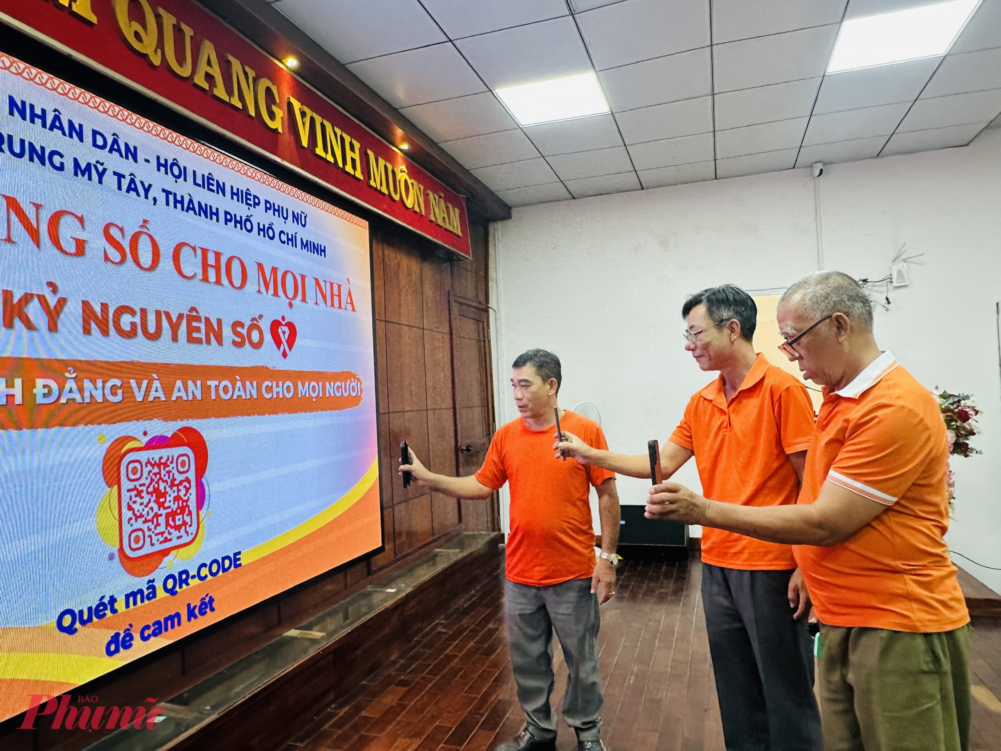 Thành viên CLB “Nam giới tiên phong thúc đẩy bình đẳng giới” khu phố 30 cùng quét mã QR để ký cam kết trực tuyến - Ảnh: Mẫn Nhi