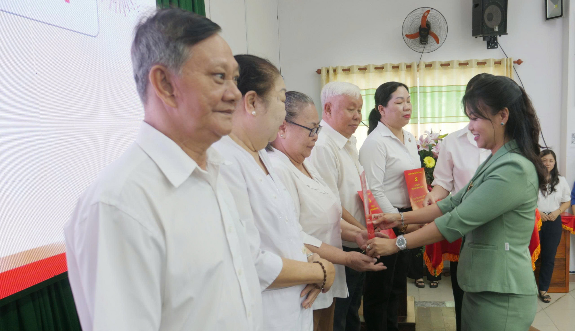 Bà Nguyễn Thị Mai Trang - Phó bí thư Thường trực Đảng ủy phường Minh Phụng - trao thẻ đảng viên đến các chi bộ