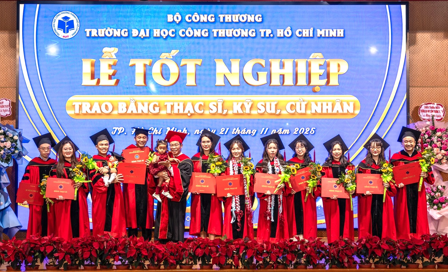 Tiến sĩ Nguyễn Xuân Hoàn (người bế em bé) trao bằng tốt nghiệp cho các tân thạc sĩ - Ảnh: HUIT