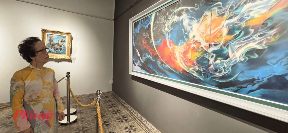 Nhà phê bình nghệ thuật Thụy Khuê bên bức tranh Thiên Thai