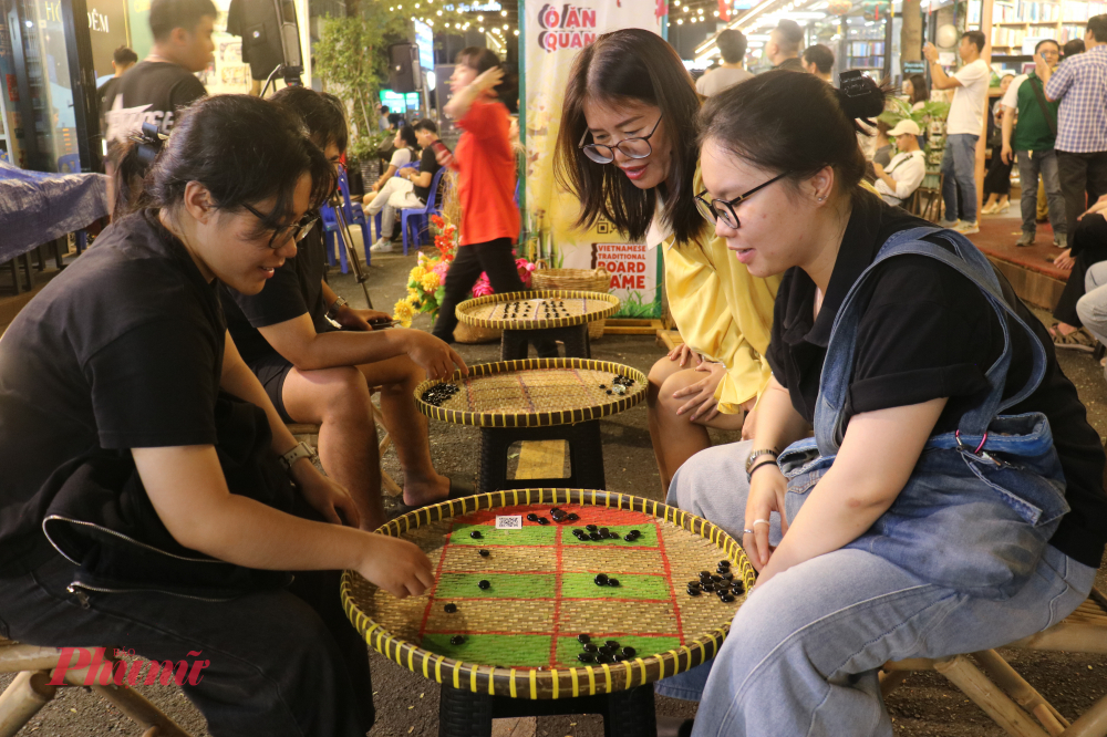 Trò chơi ô ăn quan thu hút sự tò mò của các bạn trẻ - Ảnh: Phương Nhã
