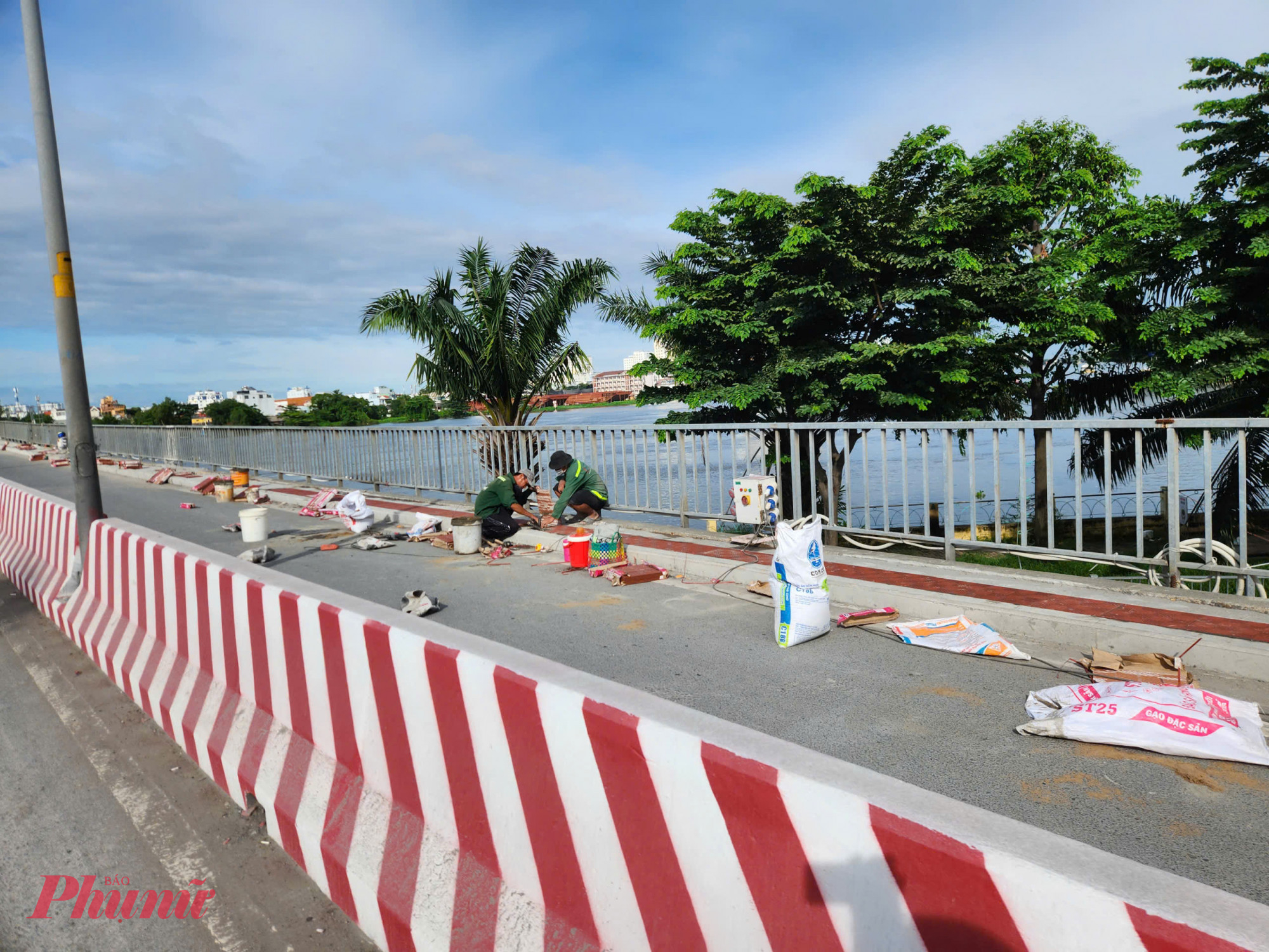 Công nhân đang hoàn thiện lề đi bộ trên cầu Bình Triệu 1 sau khi hoàn thành nâng tĩnh không - Ảnh: Nguyễn Văn