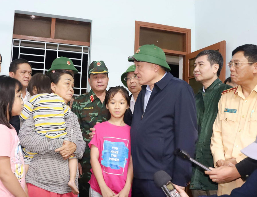 Phó Thủ tướng Thường trực Chính phủ Nguyễn Hòa Bình động viên người ân đang tránh trú lũ ở trung tâm UBND xã. - Ảnh: NT