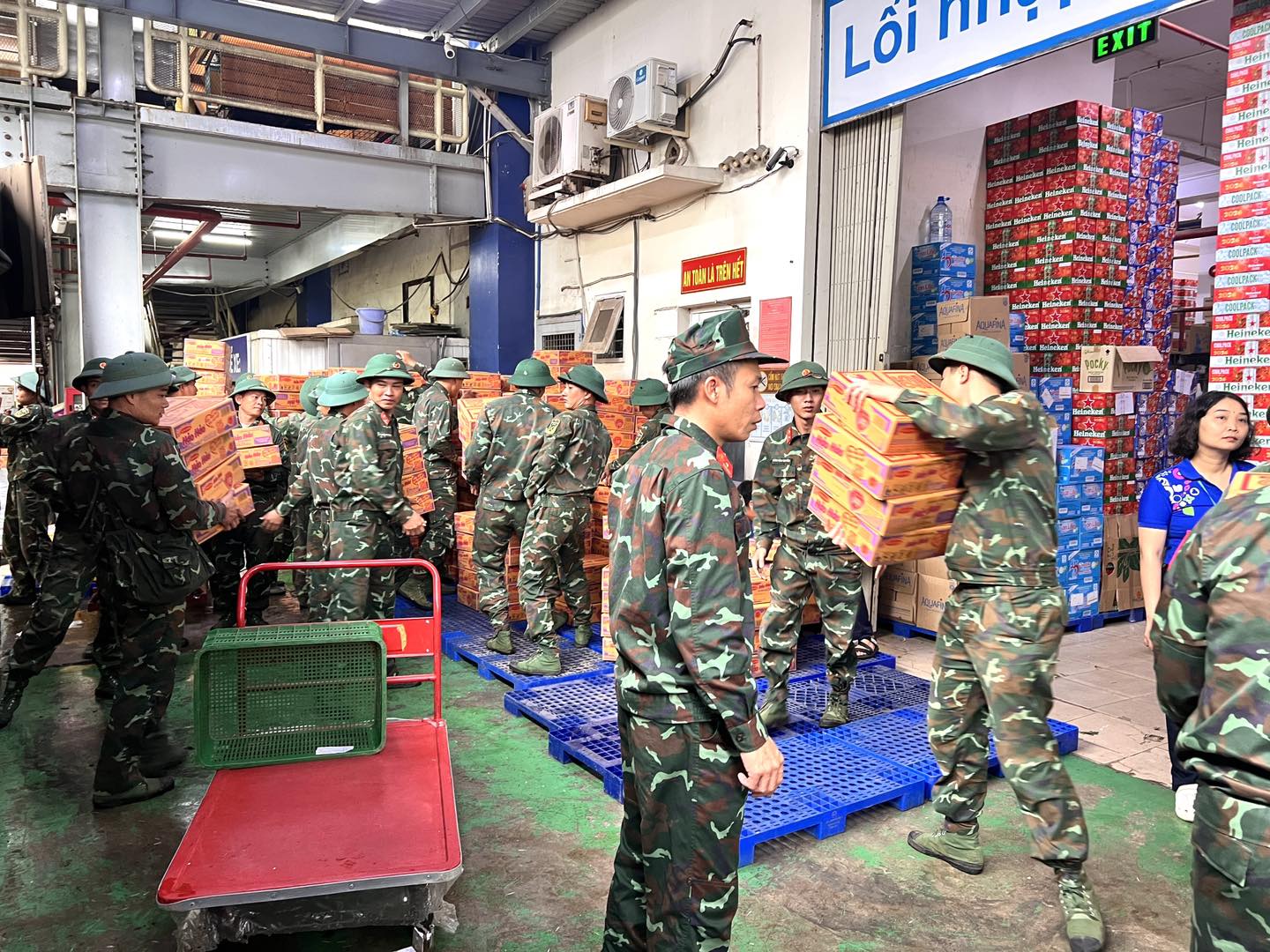 Lực lượng bộ đội hỗ trợ bốc xếp và vận chuyển hàng trăm thùng mì gói tại điểm tập kết để chuyển gấp về vùng lũ.