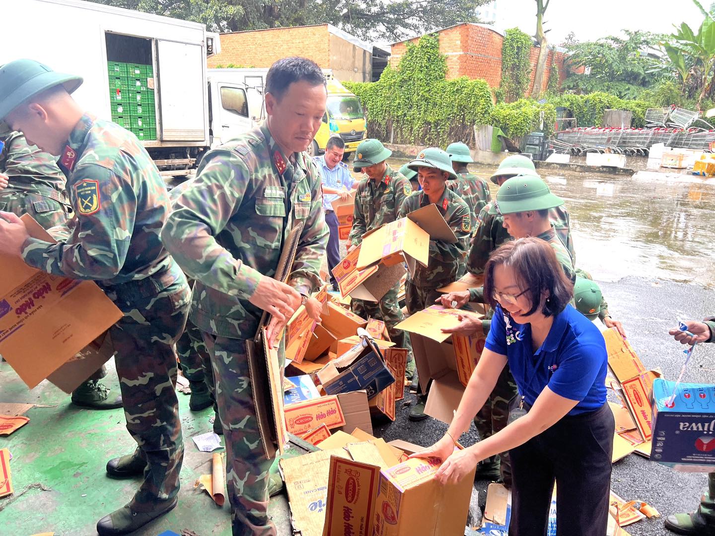 Bộ đội cùng tình nguyện viên phân loại, đóng gói nhu yếu phẩm trước khi chuyển đi cứu trợ các địa phương bị ảnh hưởng nặng bởi mưa lũ.