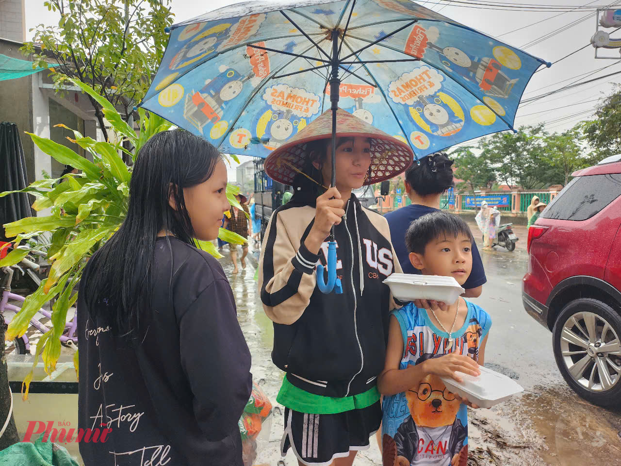 Người lớn, trẻ nhỏ không ngại đội mưa để đón nhận những tấm lòng sẻ chia từ khắp mọi miền.