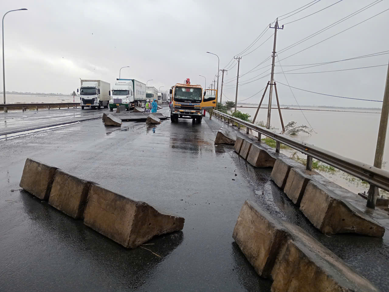 Lũ lịch lịch sử ập xuống các khối bê tông dải phân cánh bị nước lũ cuốn trôi chắn ngang đường- Ảnh: LVH