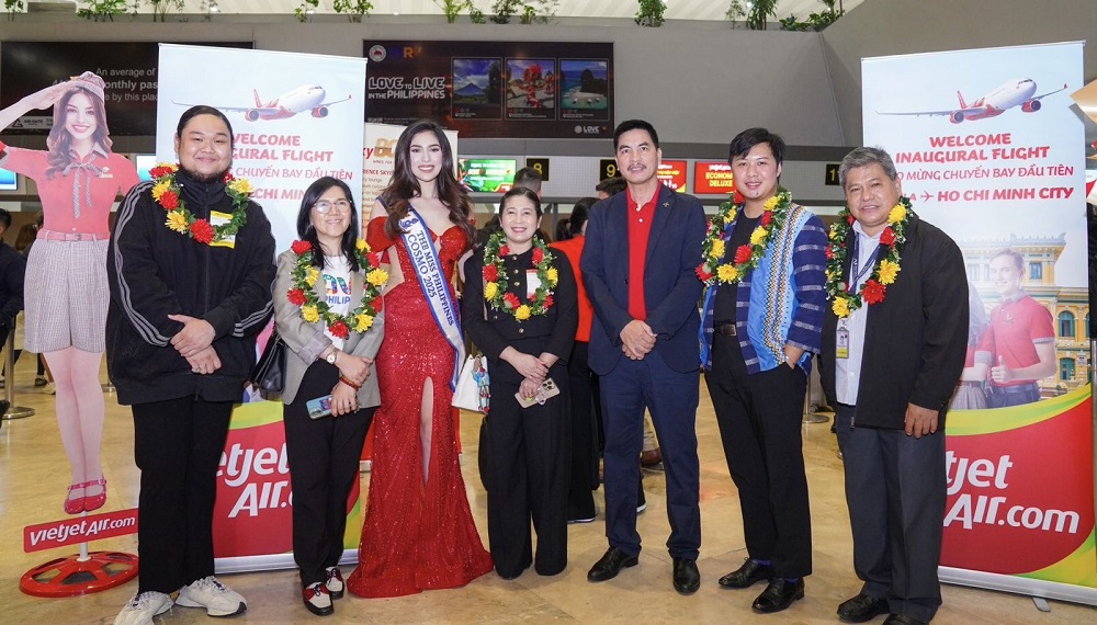 Giám đốc Thương mại Vietjet Hà Năng Việt (áo vest xanh tím than) tại sân bay Ninoy Aquino cùng Miss Cosmo Philippines 2025 Chelsea Fernandez chào đón hành khách chuyến bay đầu tiên của Vietjet - Ảnh: Tài Nguyễn