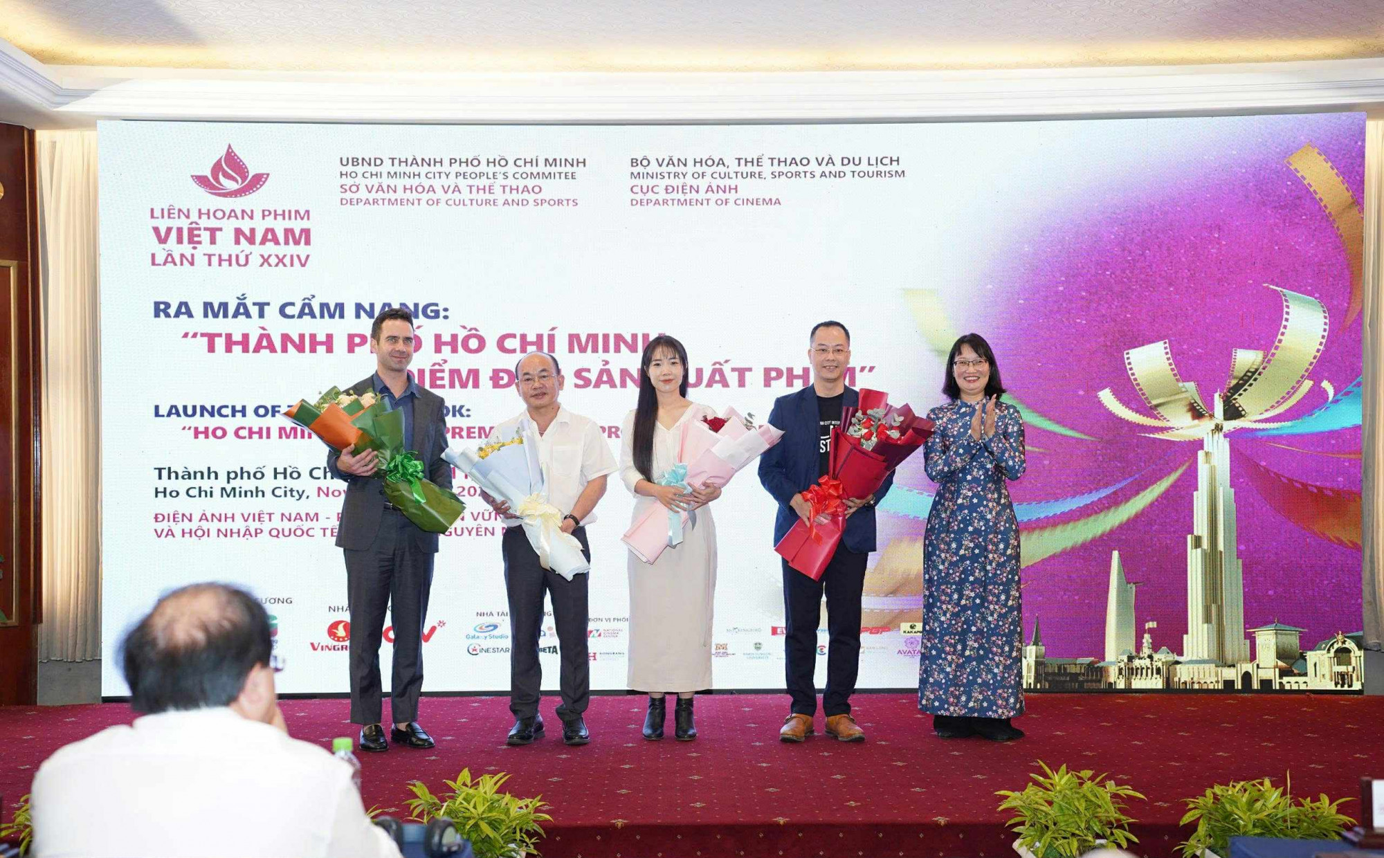 Phó chủ tịch UBND TPHCM Trần Thị Diệu Thúy (bìa phải) tặng hoa cho các cá nhân, đơn vị thực hiện cẩm nang. Ảnh: Kenvu