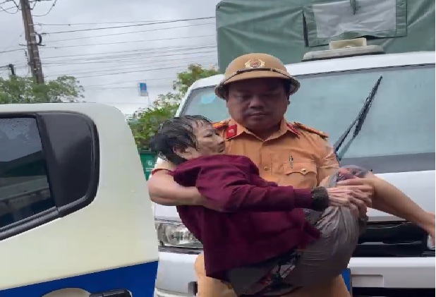 CSGT đưa cụ bà ngâm mình trong nước nhiều ngày đến bệnh viện - Ảnh: CACC