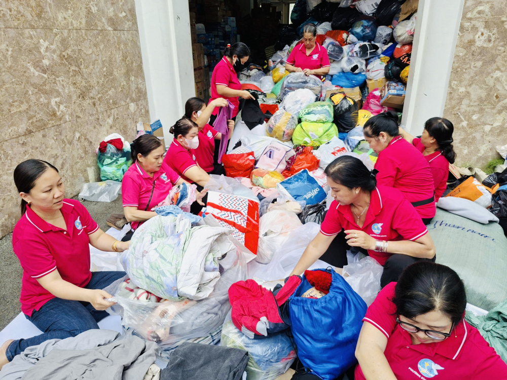 Gần 20 phụ nữ phường Bình Đông luôn túc trực để hỗ trợ phân loại, đóng gói và vận chuyển hàng hóa cứu trợ tại trụ sở Ủy ban MTTQ Việt Nam TPHCM - Ảnh: KH