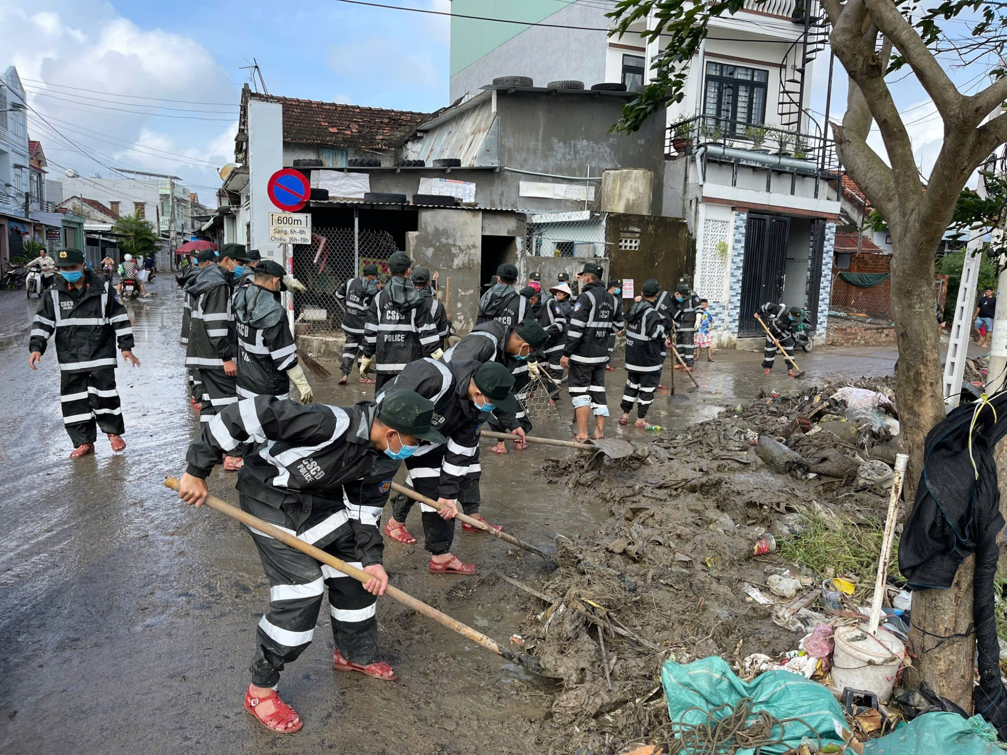 Hàng người thuộc các lực lượng quân đội công an, lực lượng địa phương đang giúp người dân khắc phục hậu quả mưa bão- Ảnh: CACC