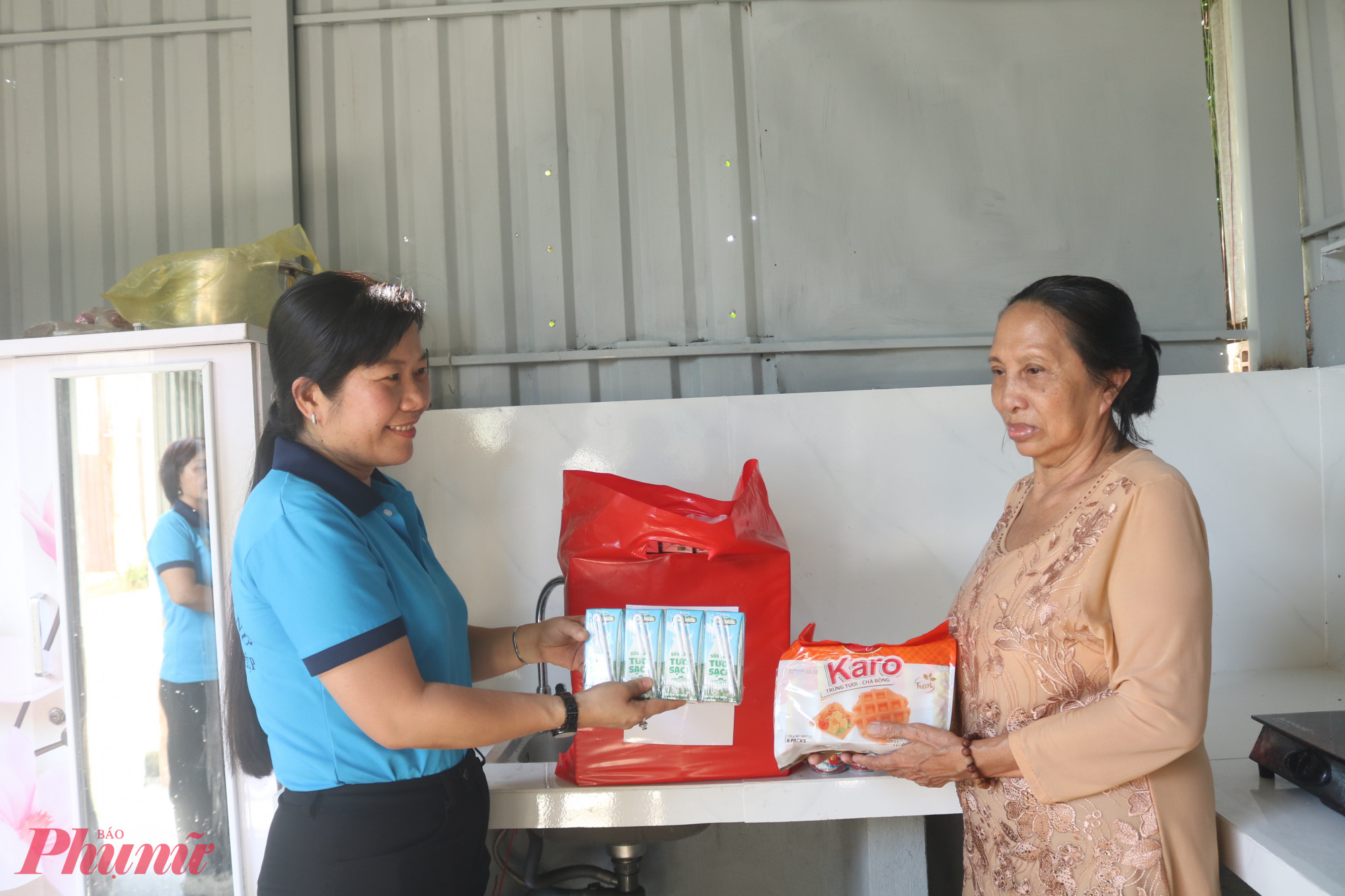 Bà Phạm Thị Mộng Hằng – Phó chủ tịch thường trực Ủy ban MTTQ Việt Nam phường Tân Thới Hiệp, Chủ tịch Hội LHPN phường (bìa trái) – tặng quà, động viên bà Thắm cố gắng điều trị bệnh - Ảnh: Mẫn Nhi