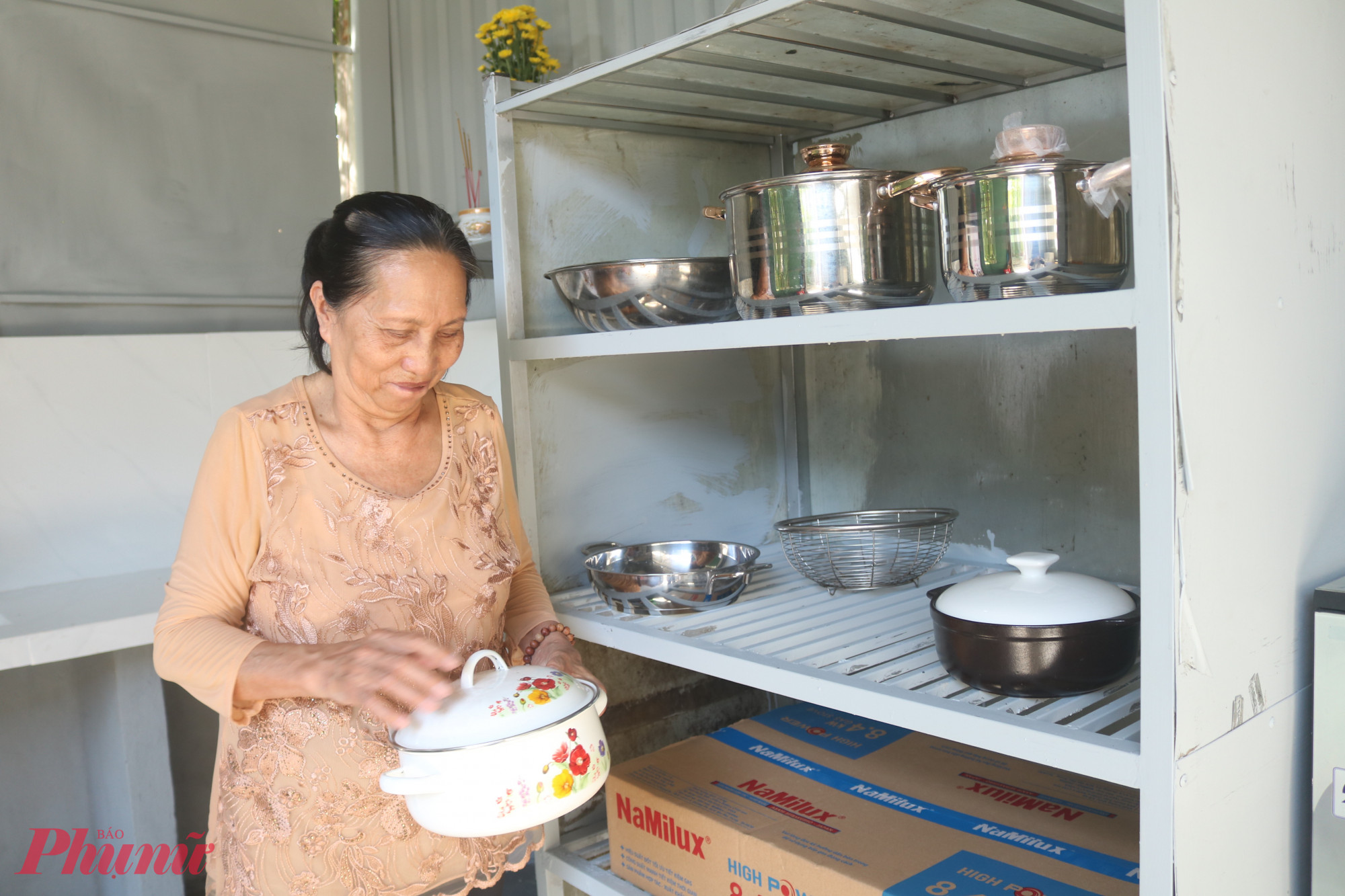 Bà Thắm cho biết rất phấn khởi trước món quà ý nghĩa của hội. Đối với bà, từng cái xoong, cái chảo đều vô cùng quý giá - Ảnh: Mẫn Nhi