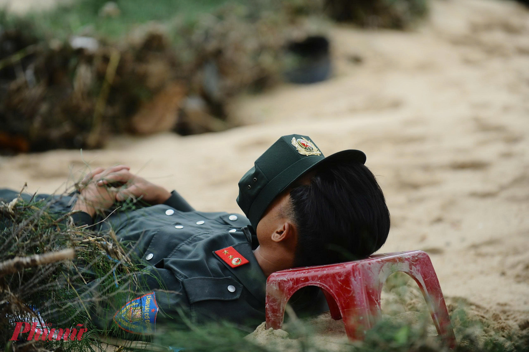 Nhiều cán bộ chiến sĩ ngã lưng ngay trên lớp cát ngỗn ngang giữa sân trường để tranh thủ chợp mắt.