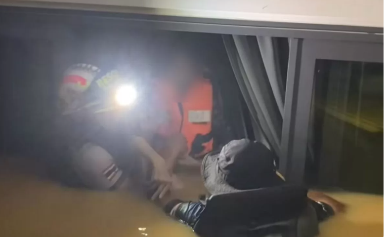 Cô con gái được giải cứu khỏi ngôi nhà bị ngập lụt ở Hat Yai, cùng với một tủ lạnh nổi chứa thi thể của người mẹ bị chết đuối. (Tác giả bức ảnh: Quyền Trung úy Wallop Boonchan)  Please credit and share this article with others using this link: https://www.bangkokpost.com/thailand/general/3144784/flood-horror-daughter-kept-drowned-mothers-body-in-floating-fridge. View our policies at http://goo.gl/9HgTd and http://goo.gl/ou6Ip. © Bangkok Post PCL. All rights reserved.