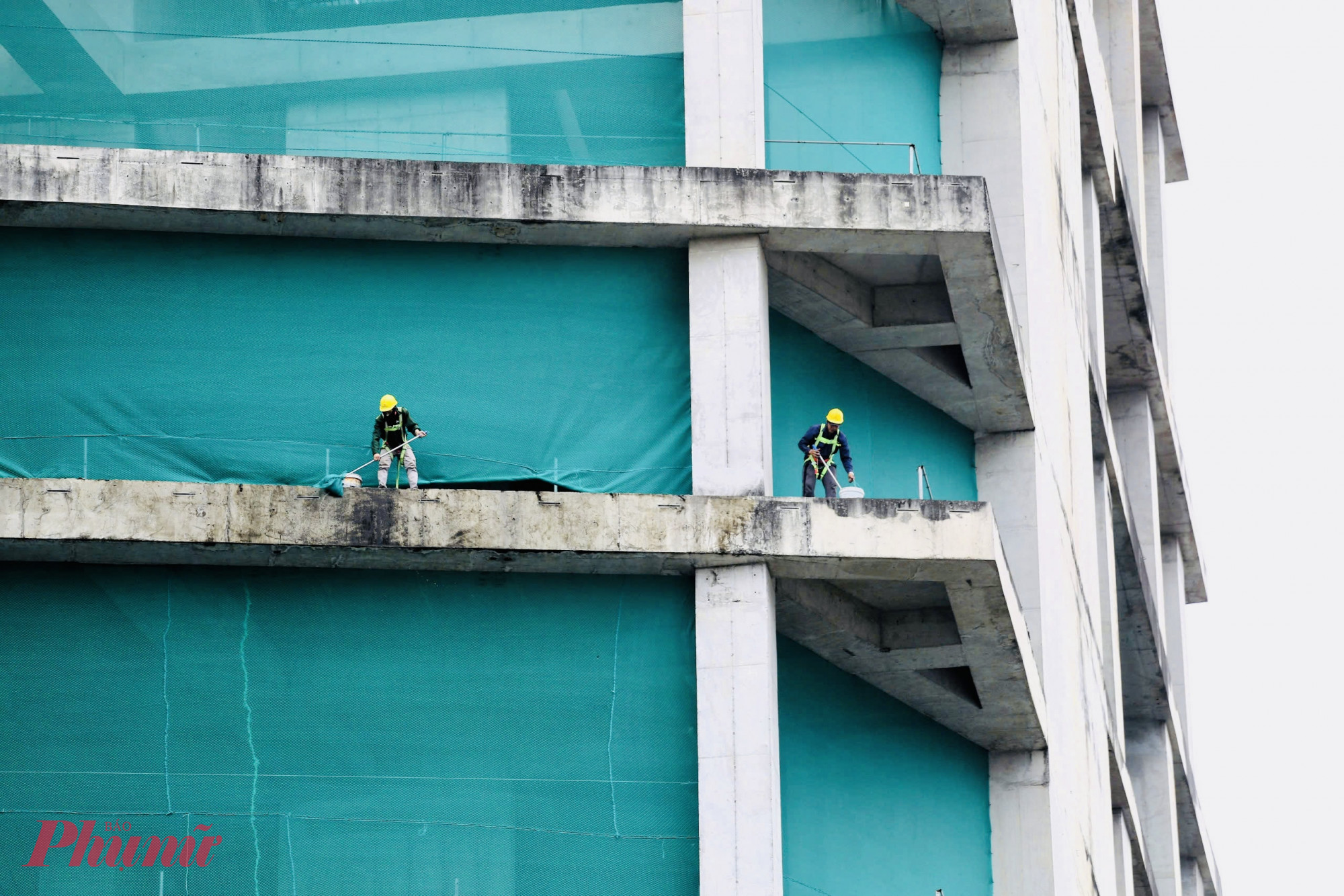 Công nhân đang tiến hành vệ sinh rong rêu bám tại công trình do một thời gian dài tạm ngưng thi công.