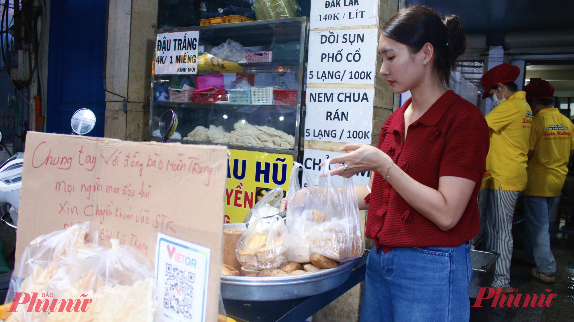 Đây là tiệm đậu hũ của gia đình chị Nguyễn Thị Thu Hồng (32 tuổi) – Hội viên phụ nữ phường Bình Lợi Trung. Chị Hồng cho biết, những ngày vừa qua, khi xem báo đài nói về tình hình bão lũ ở miền Trung,  gia đình chị cảm thấy vô cùng đồng cảm, lo lắng và thương xót bà con. Nhận được thông tin vận động từ Ủy ban MTTQ Việt Nam của Thành phố và phường Bình Lợi Trung, gia đình chị lập tức tham gia đóng góp, một số nhu yếu phẩm để gửi hỗ trợ bà con vùng lũ. Tuy nhiên, chỉ vài ngày sau, khi nghe thông báo các điểm tiếp nhận không còn nhận thêm quần áo, nhu yếu phẩm do đã đủ số lượng, gia đình chị nảy ra ý tưởng dựa vào chính công việc kinh doanh tại nhà để tiếp tục đóng góp cho bà con. Từ đó, chị bắt đầu triển khai cách làm riêng của mình để tiếp tục lan tỏa yêu thương đến miền Trung.