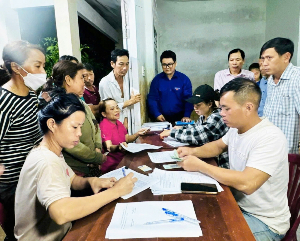 Người dân ở thôn Trung 1, xã Diên Điền, tỉnh Khánh Hòa nhận tiền hỗ trợ bị thiệt hại do lũ với mức 1 triệu đồng/người - ẢNH: HOÀNG DUNG