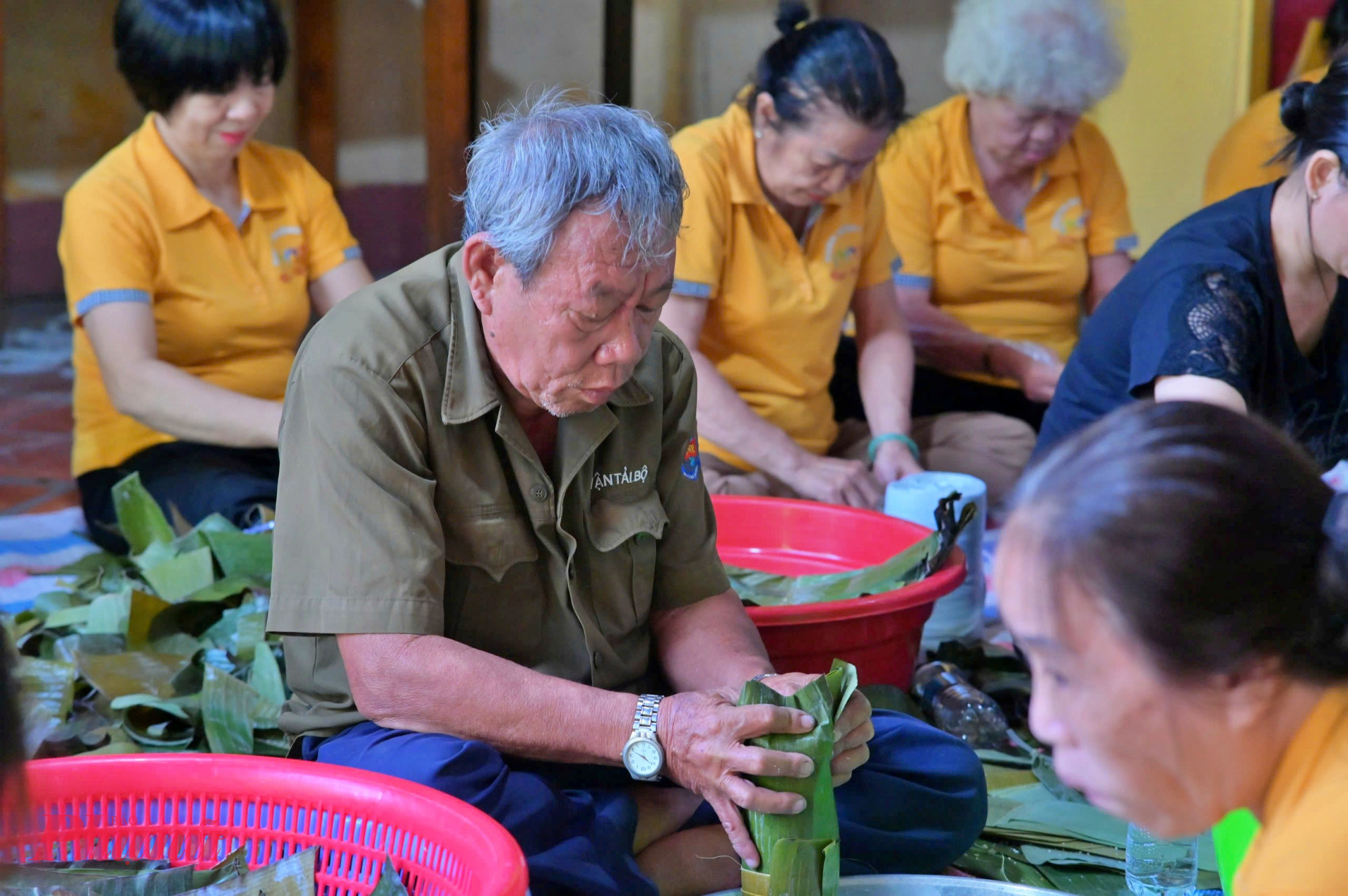 Cụ ông cũng góp sức gói bánh hỗ trợ chị em phụ nữ