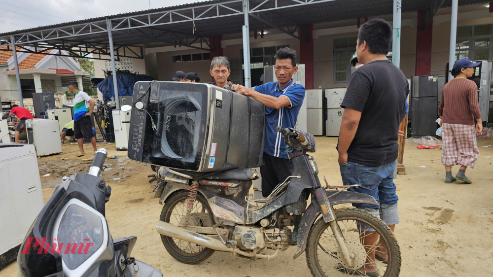 Bà con chở thiết bị hư hỏng do ngập lụt đến điểm tập kết.