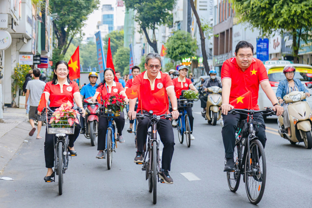 Ông Nguyễn Thành Nam - Bí thư Đảng ủy, Chủ tịch HĐND phường (giữa), bà Trần Thị Hường - Phó Bí thư Thường trực Đảng ủy phường (bìa trái) và ông Phạm Đăng Nam - Phó Chủ tịch UBND phường (bìa phải) dẫn đầu đoàn tham gia diễu hành đạp xe hoa tuyên truyền với chủ đề “ Tự Hào Bàn Cờ - Bản sắc vẹn nguyên”