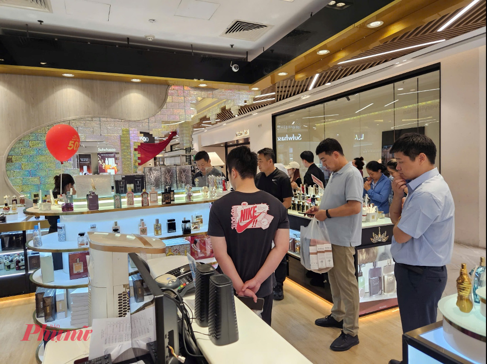 quầy nước hoa tại khu vực mỹ phẩm của trung tâm thương mại cũng đông không kém. Nhiều dòng như Gucci, Versace,… được giảm đến 50%, nên khách liên tục dừng lại thử mùi và xem giá.