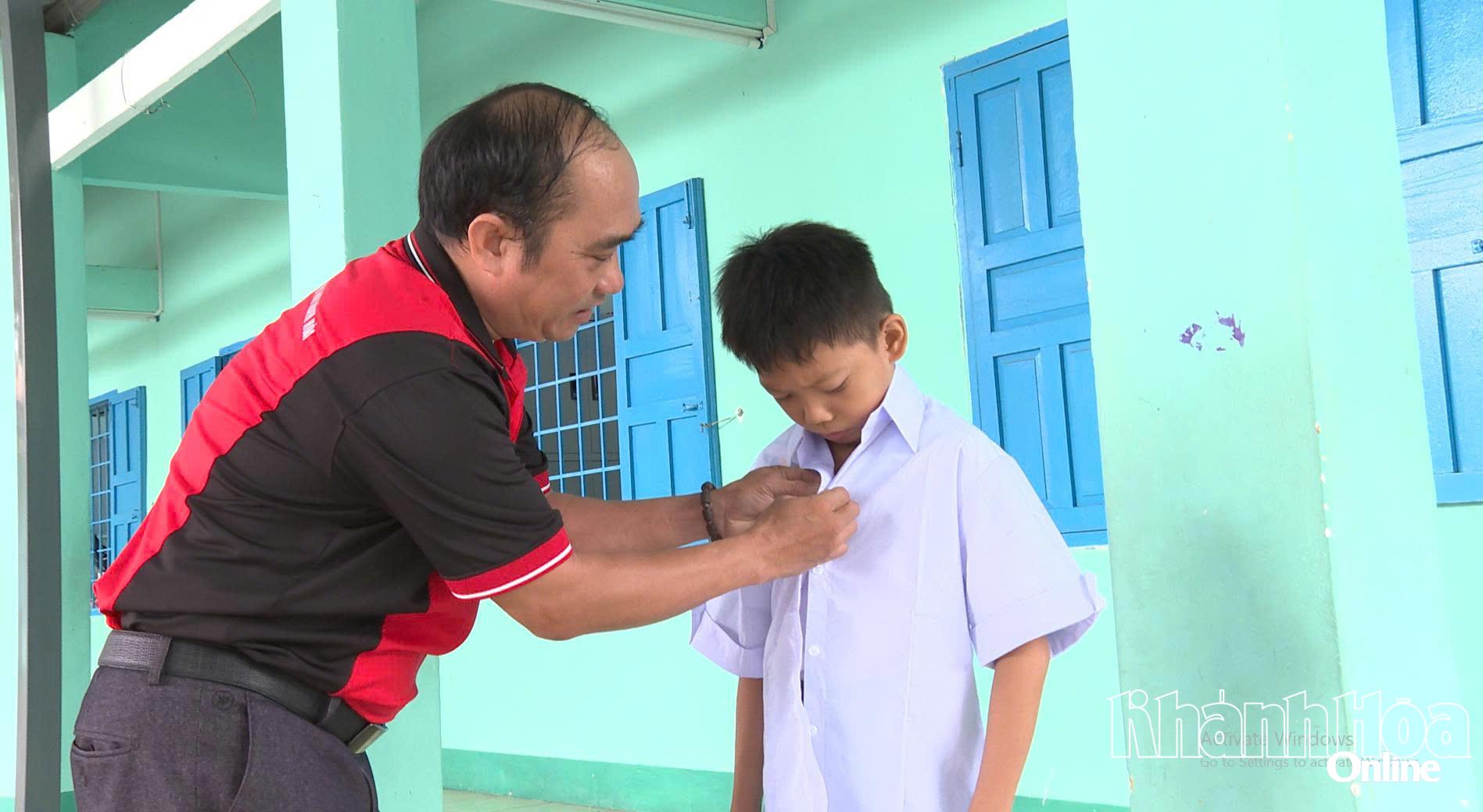 Ông Nguyễn Xuân Duy - Phó Giám đốc Báo và Phát thanh, Truyền hình Khánh Hòa tặng đồng phục cho học sinh Trường Tiểu học Bảo An 1, phường Bảo An - Ảnh: Báo Khánh Hòa