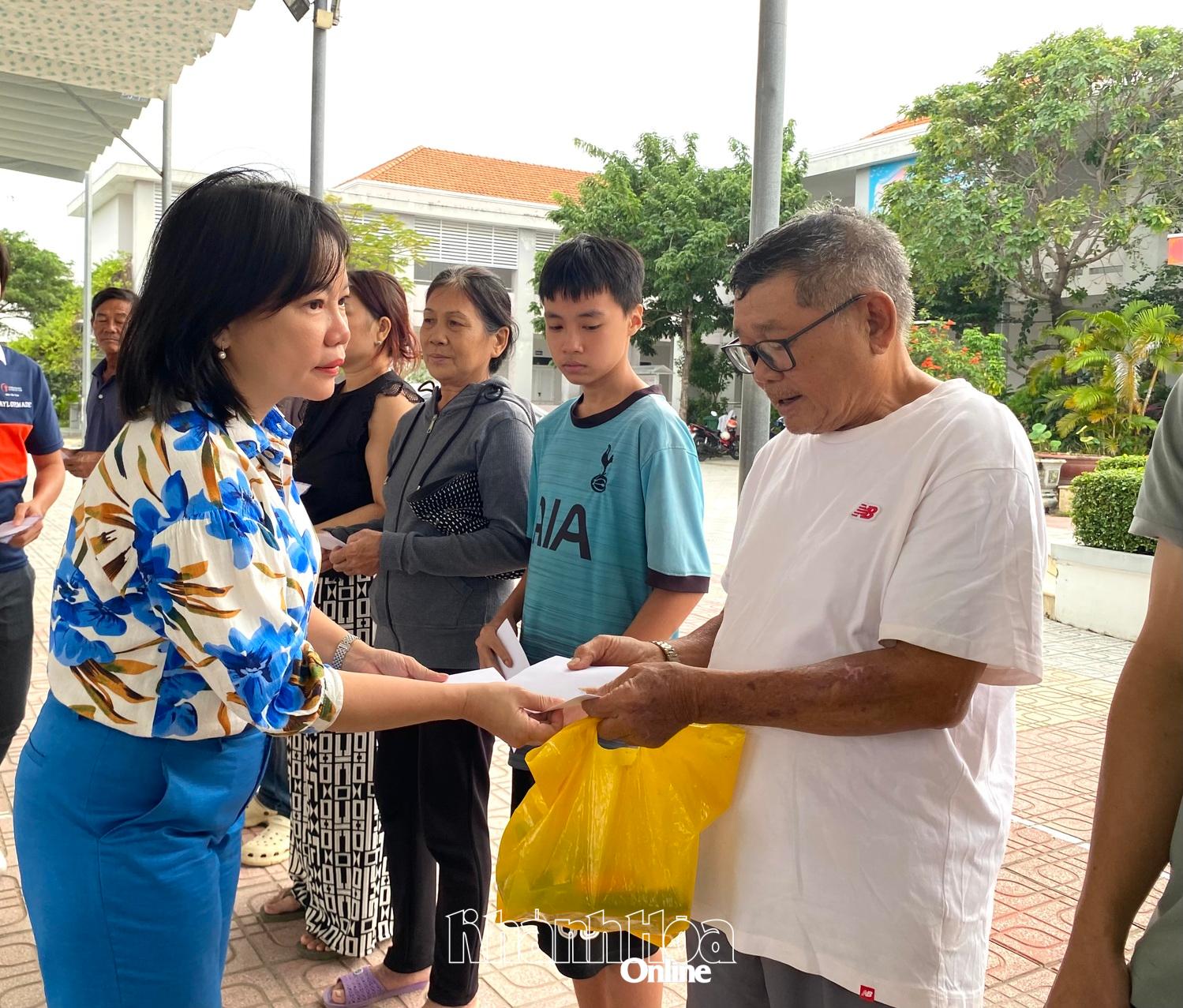 Bà Thái Thị Lệ Hằng - Giám đốc Báo và Phát thanh, Truyền hình Khánh Hòa trao quà cho người dân Tổ dân phố Thủy Tú.